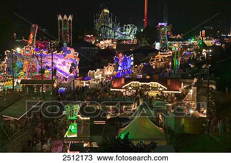 Stock Image - High angle view of people in amusement park at night . Fotosearch