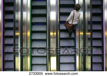 High angle view of person standing on escalator View Large Photo Image Stock Photography - High angle view of person standing on escalator . Fotosearch