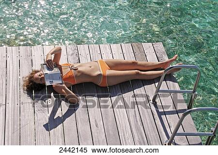 High angle view of woman reading book on jetty View Large Photo Image Stock Photography - High angle view of woman reading book on jetty . Fotosearch
