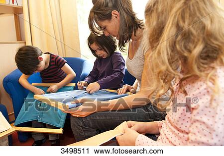 Kindergarten teacher and children playing with fasteners frames View Large Photo Image Stock Image - Kindergarten teacher and children playing with fasteners frames . Fotosearch