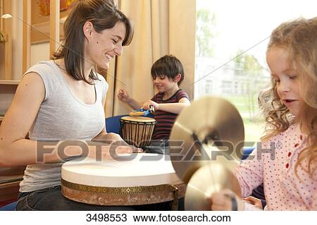 Kindergarten teacher and children making music View Large Photo Image Stock Image - Kindergarten teacher and children making music . Fotosearch