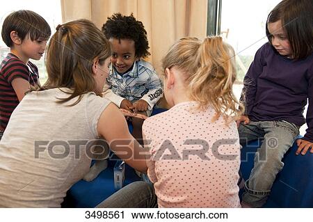 Kindergarten teacher applying a plaster on boys leg View Large Photo Image Stock Image - Kindergarten teacher applying a plaster on boys leg . Fotosearch