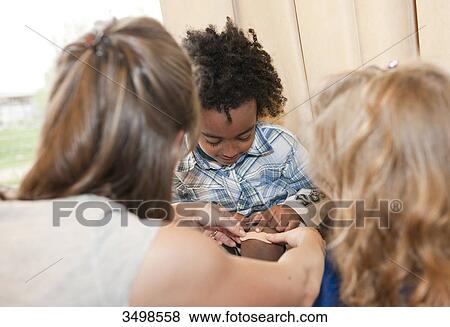 Stock Photo - Kindergarten teacher applying a plaster on boys leg . Fotosearch