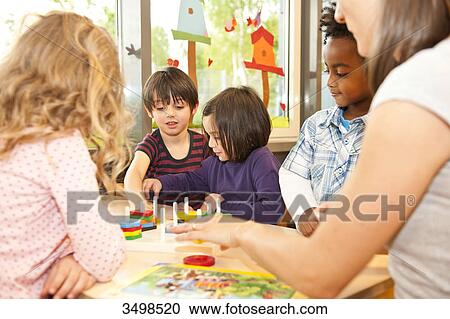 Kindergarten teacher playing with children View Large Photo Image Stock Image - Kindergarten teacher playing with children . Fotosearch