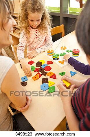 Kindergarten teacher playing with children View Large Photo Image Stock Image - Kindergarten teacher playing with children . Fotosearch