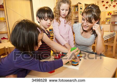 Kindergarten teacher playing with children View Large Photo Image Stock Photo - Kindergarten teacher playing with children . Fotosearch
