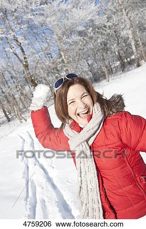 Stock Photograph - Laughing woman throwing snowball, Tannheimer Tal, Tyrol, Austria . Fotosearch