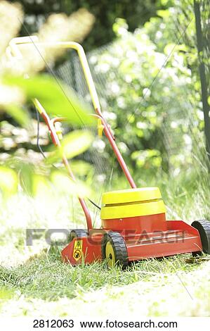 Lawn mower in garden View Large Photo Image Stock Image - Lawn mower in garden . Fotosearch