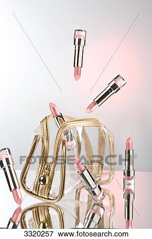 Stock Photo - Lipsticks hovering around a cosmetic bag . Fotosearch
