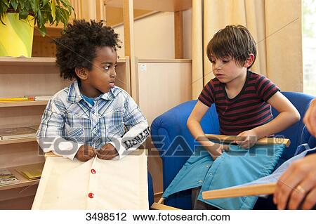Stock Image - Little boys buttoning . Fotosearch