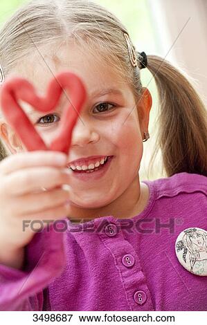 Stock Photo - Little girl holding a self-made heart, portrait . Fotosearch