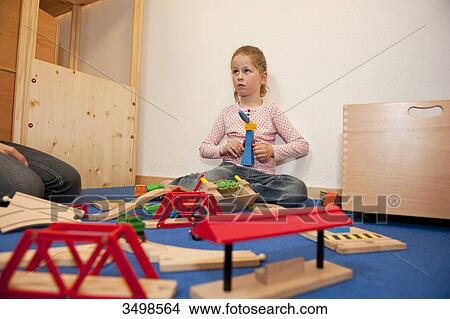 Little girl playing with toys on the floor, low angle view View Large Photo Image Picture - Little girl playing with toys on the floor, low angle view . Fotosearch