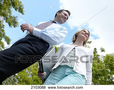 Low angle view of businessman and businesswoman smiling View Large Photo Image Stock Photo - Low angle view of businessman and businesswoman smiling . Fotosearch