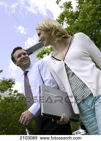 Low angle view of businessman and businesswoman smiling View Large Photo Image Stock Photo - Low angle view of businessman and businesswoman smiling . Fotosearch