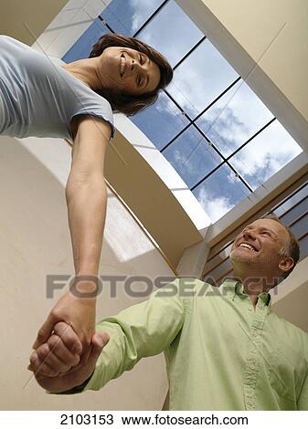 Low angle view of couple smiling View Large Photo Image Stock Image - Low angle view of couple smiling . Fotosearch