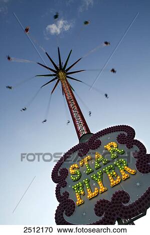 Low angle view of people on chain swing ride View Large Photo Image Stock Image - Low angle view of people on chain swing ride . Fotosearch