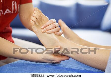 Stock Image - Low section view of person receiving foot massage . Fotosearch