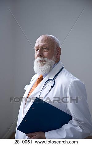 Stock Image - Male doctor holding clipboard . Fotosearch