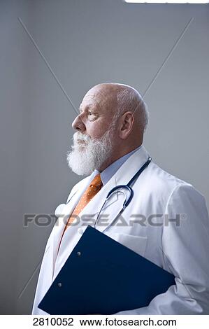 Stock Image - Male doctor holding clipboard . Fotosearch