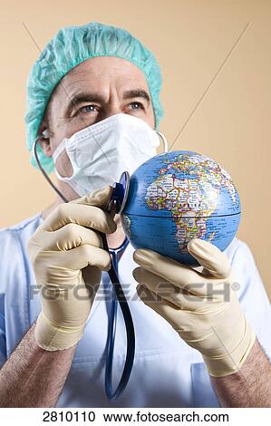 Stock Image - Male surgeon examining globe with stethoscope . Fotosearch