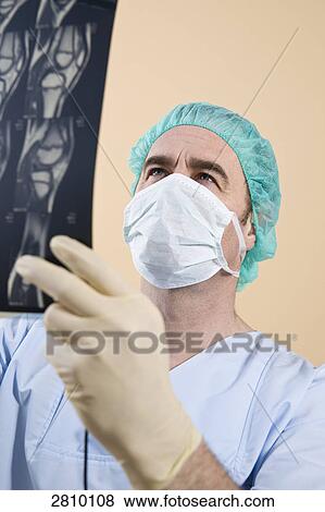 Stock Photo - Male surgeon examining x-ray . Fotosearch