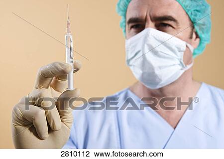 Male surgeon holding syringe View Large Photo Image Stock Image - Male surgeon holding syringe . Fotosearch