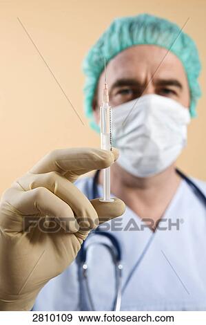 Stock Photo - Male surgeon holding syringe . Fotosearch
