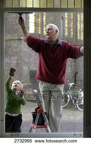 Stock Photography - Man and his grandson cleaning window . Fotosearch