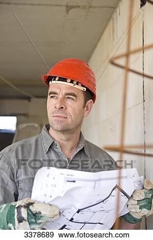 Man holding plan on construction site, low angle view View Large Photo Image Stock Photo - Man holding plan on construction site, low angle view . Fotosearch