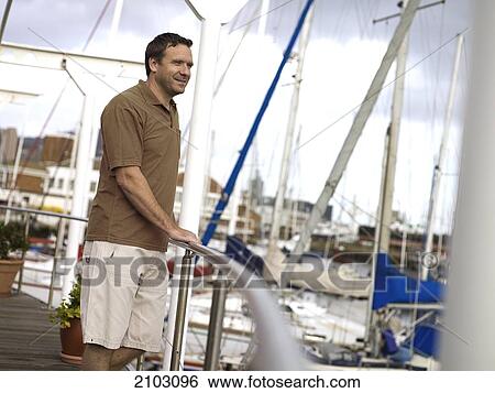 Man leaning on railing and smiling View Large Photo Image Stock Photograph - Man leaning on railing and smiling . Fotosearch