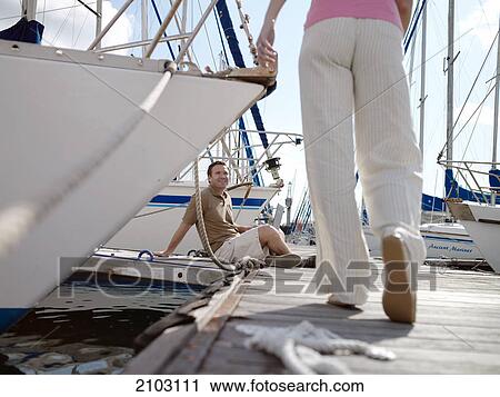 Man looking at woman walking on pier View Large Photo Image Stock Image - Man looking at woman walking on pier . Fotosearch