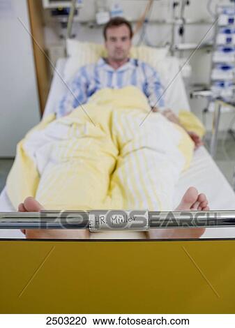 Stock Image - Man lying in hospital bed . Fotosearch
