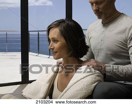 Picture - Man massaging her wife's shoulders . Fotosearch