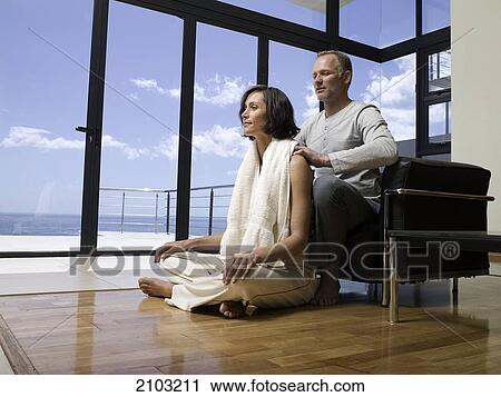 Man massaging her wife's shoulders View Large Photo Image Stock Image - Man massaging her wife's shoulders . Fotosearch