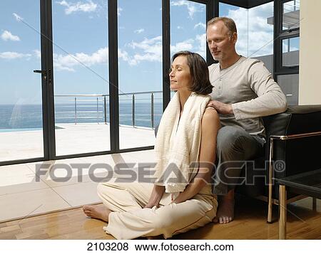Man massaging her wife's shoulders View Large Photo Image Stock Photo - Man massaging her wife's shoulders . Fotosearch