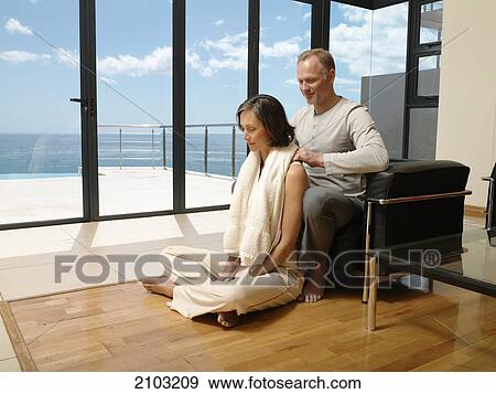 Stock Photo - Man massaging her wife's shoulders . Fotosearch
