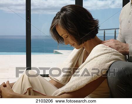 Man massaging her wife's shoulders View Large Photo Image Stock Photograph - Man massaging her wife's shoulders . Fotosearch