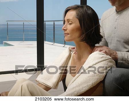 Man massaging her wife's shoulders View Large Photo Image Stock Photography - Man massaging her wife's shoulders . Fotosearch