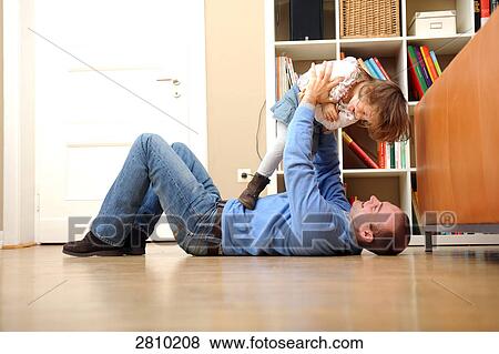 Man playing with his daughter View Large Photo Image Stock Photo - Man playing with his daughter . Fotosearch