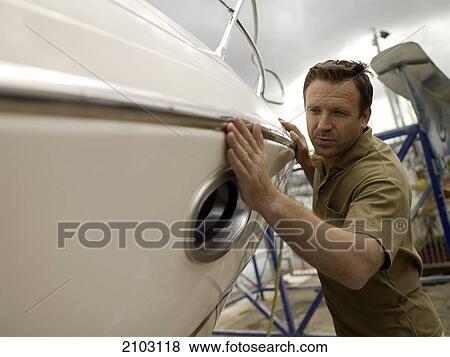 Man pushing boat at harbor View Large Photo Image Stock Photo - Man pushing boat at harbor . Fotosearch