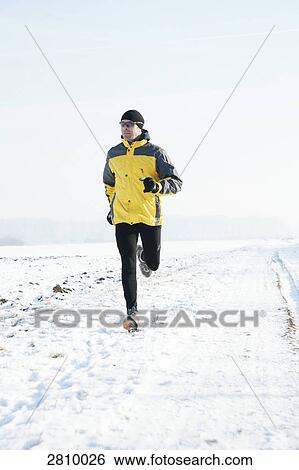Man running in snow covered landscape View Large Photo Image Stock Photograph - Man running in snow covered landscape . Fotosearch