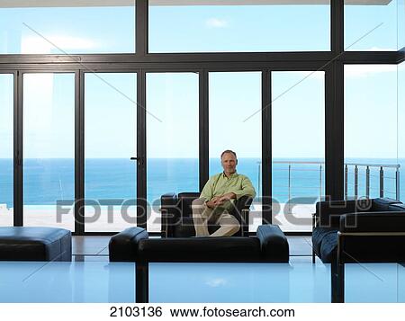 Man sitting in armchair View Large Photo Image Stock Photograph - Man sitting in armchair . Fotosearch