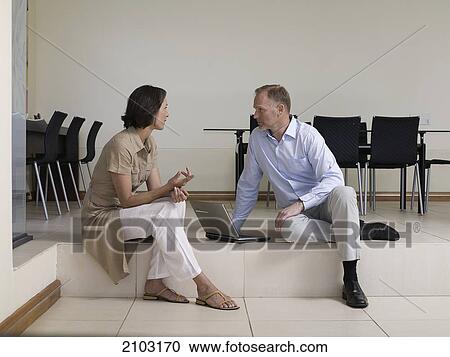 Stock Image - Man talking to his wife in living room . Fotosearch