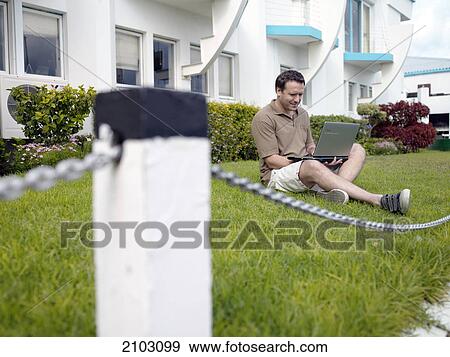 Man using laptop at frontyard View Large Photo Image Stock Photo - Man using laptop at frontyard . Fotosearch