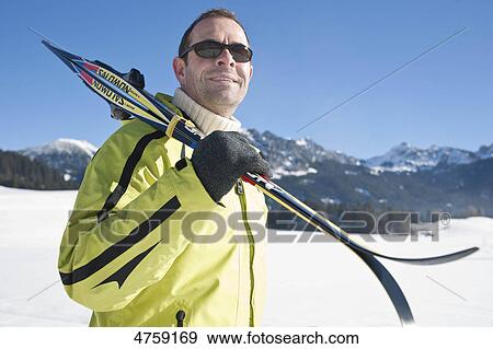 Stock Photo - Man with skis in winter landscape, Tannheimer Tal, Tyrol, Austria . Fotosearch
