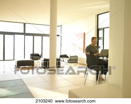 Man working on laptop at table View Large Photo Image Stock Image - Man working on laptop at table . Fotosearch