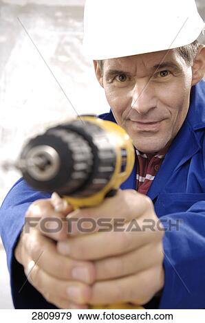 Stock Photo - Manual worker holding hand drill . Fotosearch
