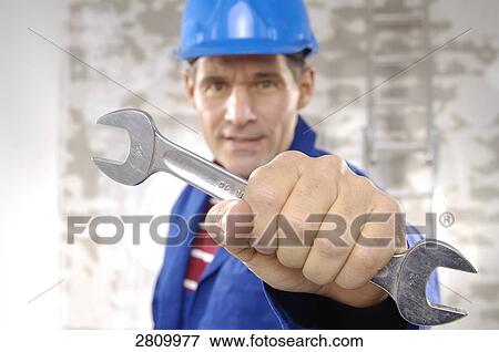 Stock Photo - Manual worker holding spanner . Fotosearch