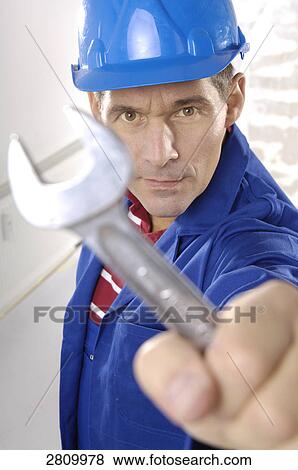 Stock Photo - Manual worker holding spanner . Fotosearch