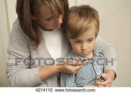 Stock Image - Mother giving son medicine . Fotosearch
